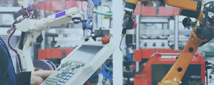 Tecnico che programma una macchina industriale all'interno di un impianto automatizzato, rappresentazione dell'attività di un costruttore di macchine industriali