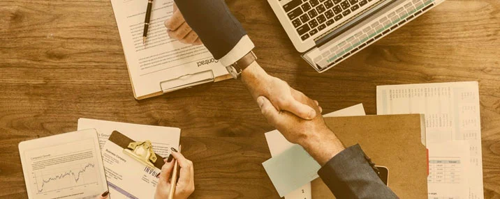 Scrivania con report tecnici, documenti e dispositivi digitali gestiti da un team, rappresentazione delle attività tipiche di un facility manager