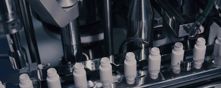 Linea di produzione industriale con componenti meccanici in acciaio, simbolo dell'attività di una società di ingegneria nel settore dell'automazione.